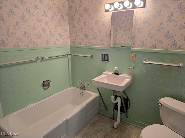 bathroom with toilet, a bathing tub, and sink