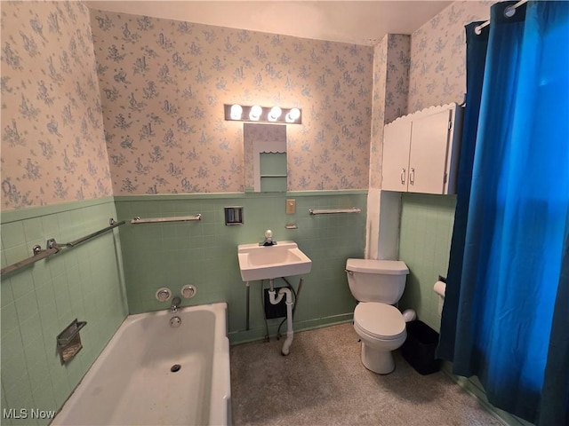 bathroom with tile walls, sink, a bathing tub, and toilet