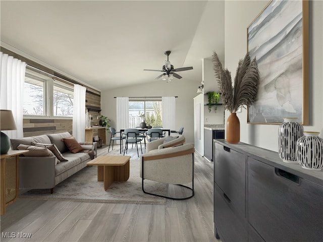 living room with lofted ceiling, hardwood / wood-style flooring, and ceiling fan