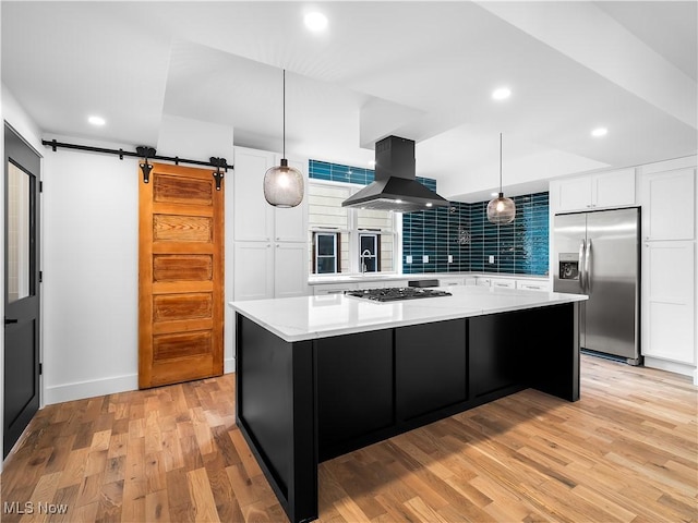 kitchen with a large island, white cabinetry, island exhaust hood, stainless steel appliances, and a barn door