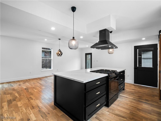 kitchen featuring a kitchen island, black range with gas stovetop, hanging light fixtures, island exhaust hood, and light wood-type flooring