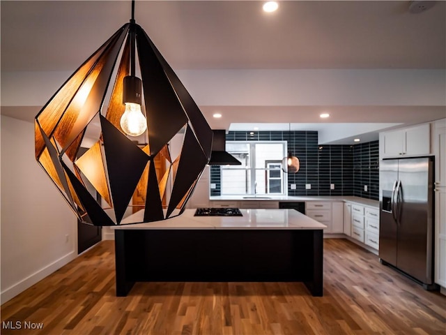 kitchen featuring white cabinets, dark hardwood / wood-style floors, a center island, and black appliances