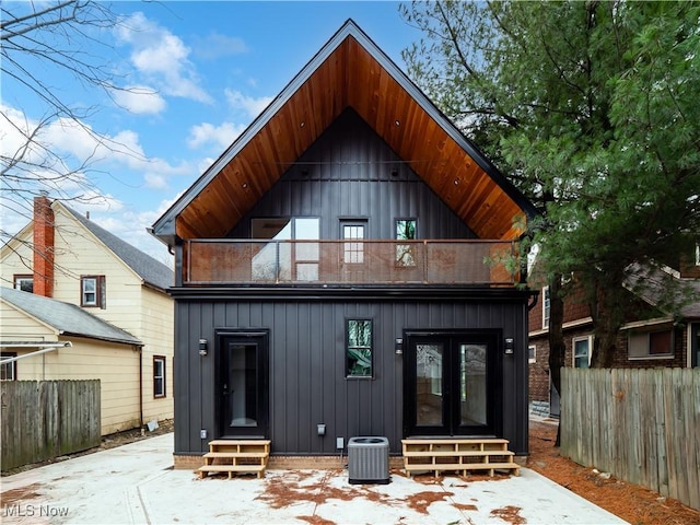 back of house with french doors, a balcony, and central AC