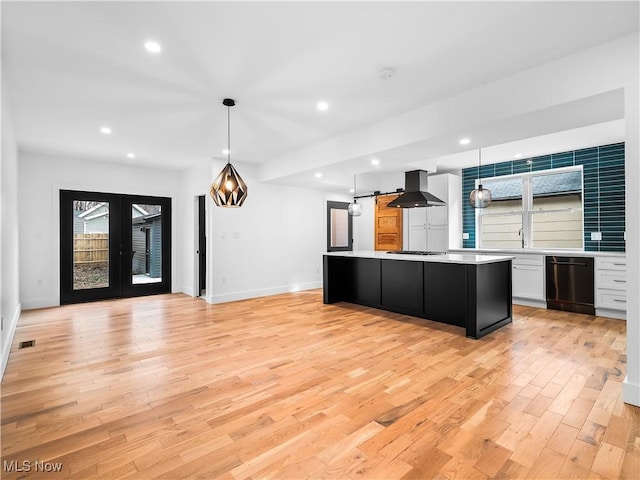 kitchen featuring dishwasher, white cabinets, hanging light fixtures, a center island, and exhaust hood