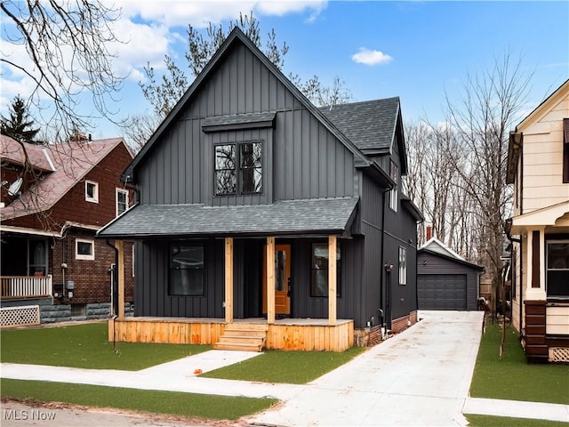 view of front of home featuring a garage, a front yard, an outbuilding, and covered porch