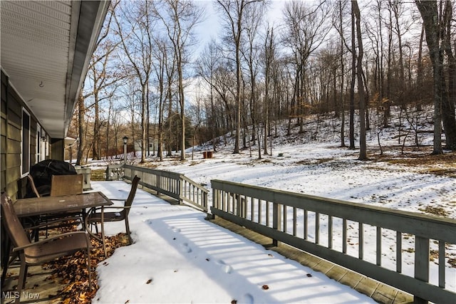 snow covered deck with a grill