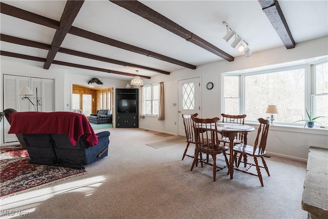 carpeted dining room featuring beamed ceiling