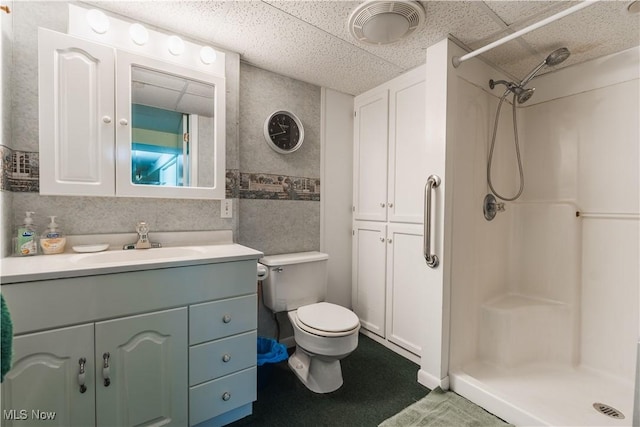 bathroom with vanity, toilet, tile walls, and walk in shower