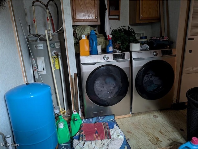 laundry room with water heater, cabinets, hardwood / wood-style floors, and independent washer and dryer