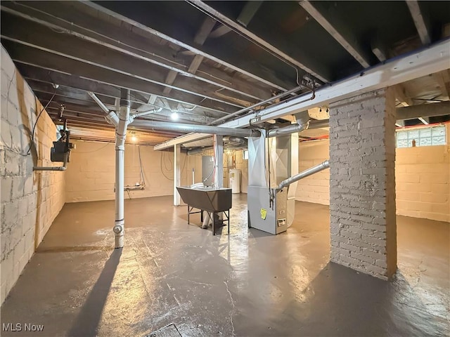 basement featuring water heater and heating unit