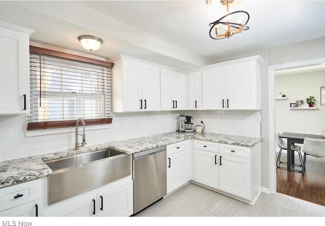 kitchen with sink, backsplash, light stone countertops, white cabinets, and stainless steel dishwasher