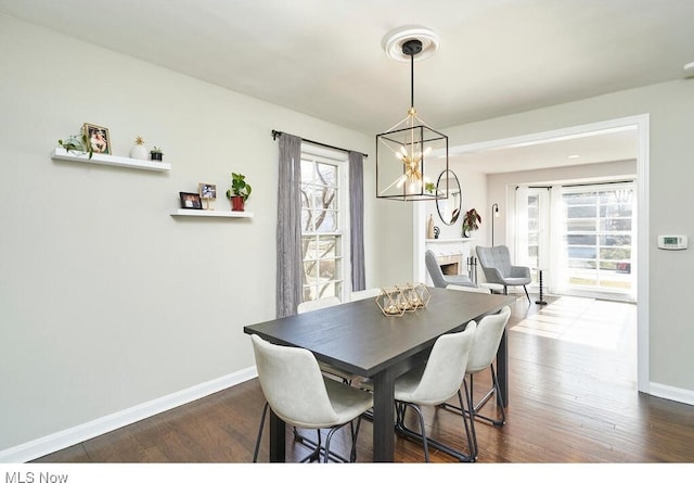 dining area featuring a notable chandelier, dark wood-type flooring, and plenty of natural light