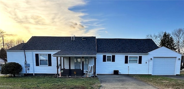 view of front of home featuring a porch, a garage, and a yard