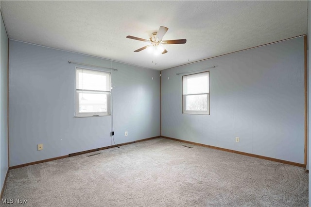 carpeted spare room with ceiling fan