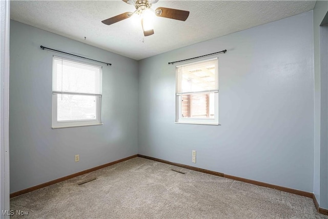 carpeted spare room featuring ceiling fan and a textured ceiling