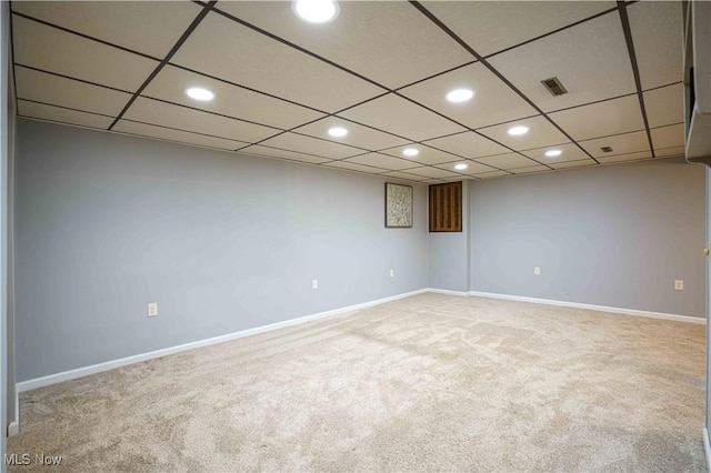 carpeted empty room featuring a paneled ceiling