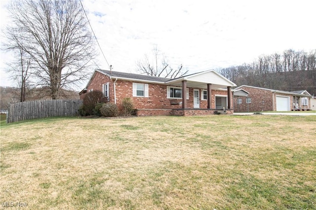 ranch-style house featuring a garage, covered porch, and a front lawn