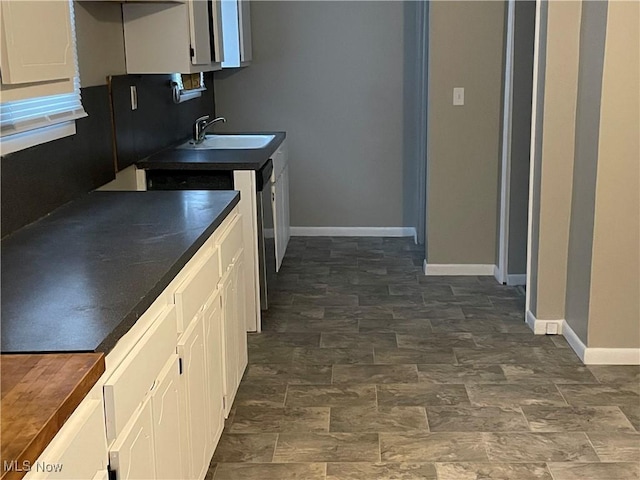 kitchen featuring dishwasher, sink, and white cabinets