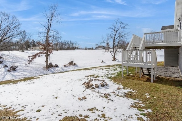 yard covered in snow featuring a wooden deck