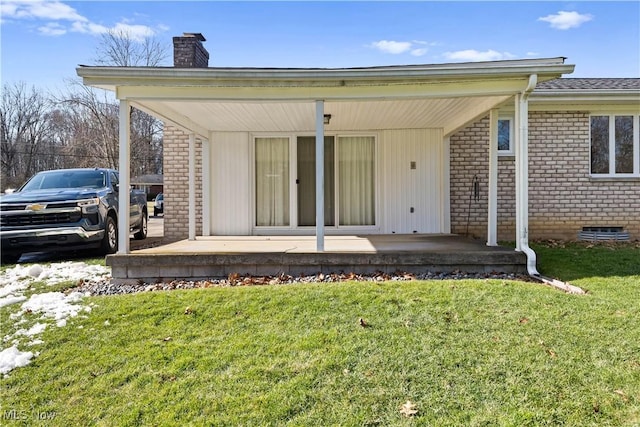 rear view of property featuring covered porch and a lawn