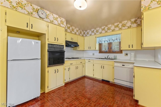 kitchen featuring white appliances, cream cabinets, and sink