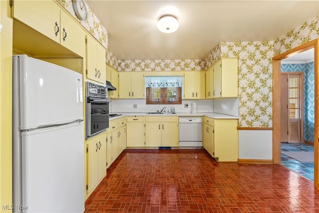 kitchen featuring cream cabinets, sink, and white appliances