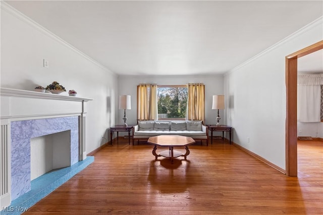 living room featuring a premium fireplace, wood-type flooring, and ornamental molding