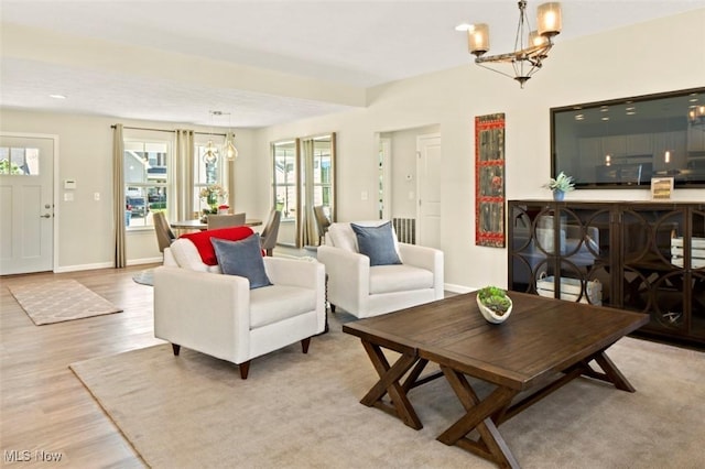 living room with light wood-type flooring and a chandelier