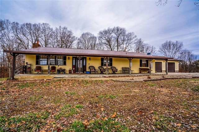 ranch-style home featuring a garage and covered porch