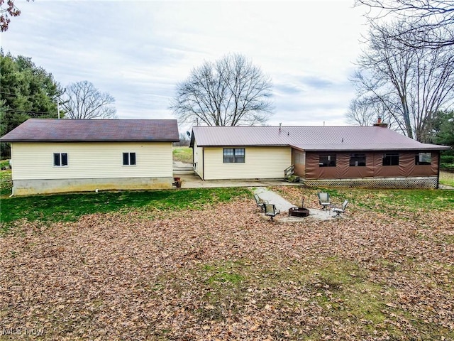 rear view of property featuring an outdoor fire pit and a patio area