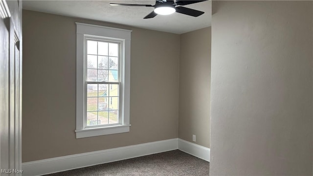 carpeted spare room featuring ceiling fan