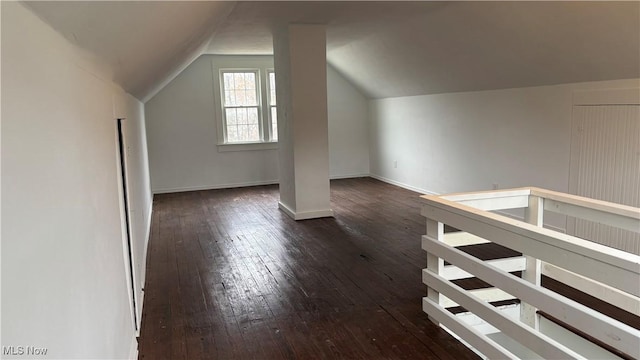 bonus room with lofted ceiling and dark wood-type flooring