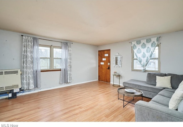 living room with wood-type flooring and heating unit