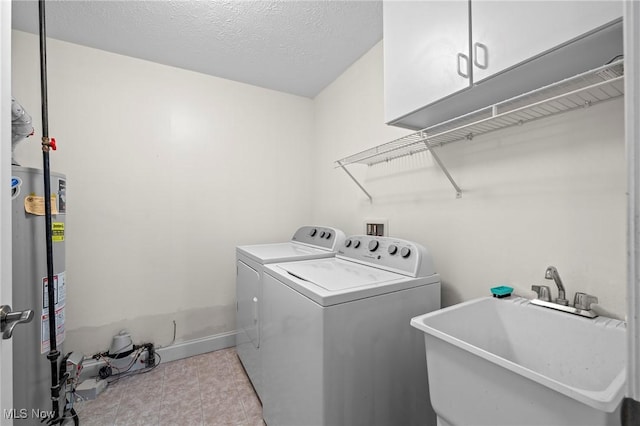 washroom with sink, cabinets, a textured ceiling, washing machine and dryer, and water heater