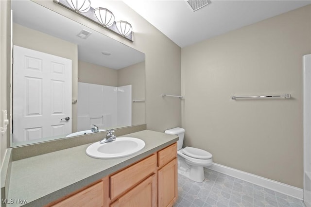 bathroom with vanity, toilet, and a shower