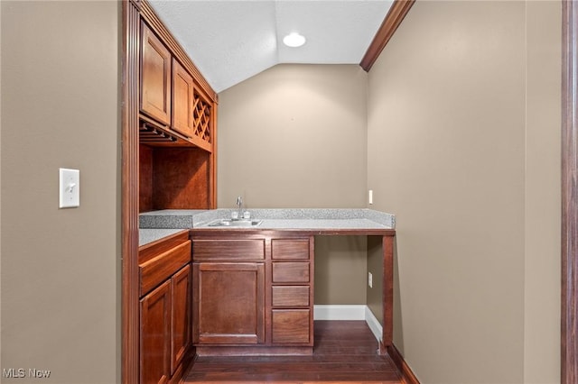 bar featuring vaulted ceiling, dark hardwood / wood-style floors, and sink