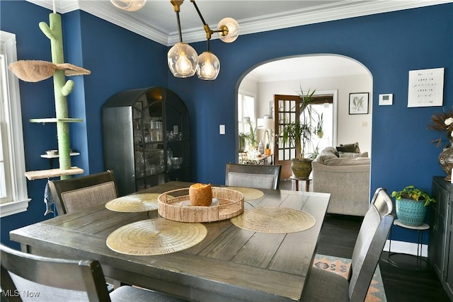 dining room featuring hardwood / wood-style flooring, ornamental molding, and an inviting chandelier