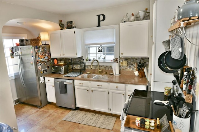 kitchen featuring tasteful backsplash, sink, stainless steel appliances, and white cabinets