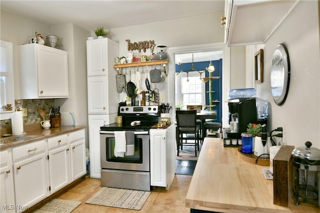 kitchen featuring white cabinetry, light tile patterned floors, backsplash, and electric stove