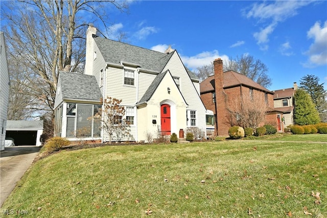 view of front facade featuring a garage, an outdoor structure, and a front yard