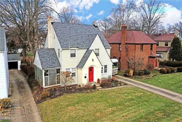 view of front facade with a garage, an outdoor structure, and a front lawn