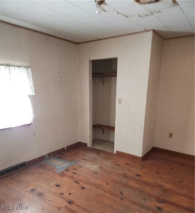 unfurnished bedroom featuring hardwood / wood-style flooring and a closet