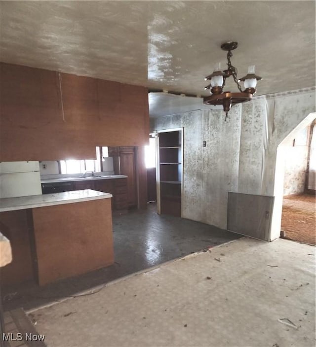 kitchen with white fridge, pendant lighting, and a chandelier