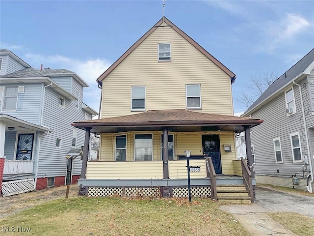 traditional style home featuring a porch and a front yard