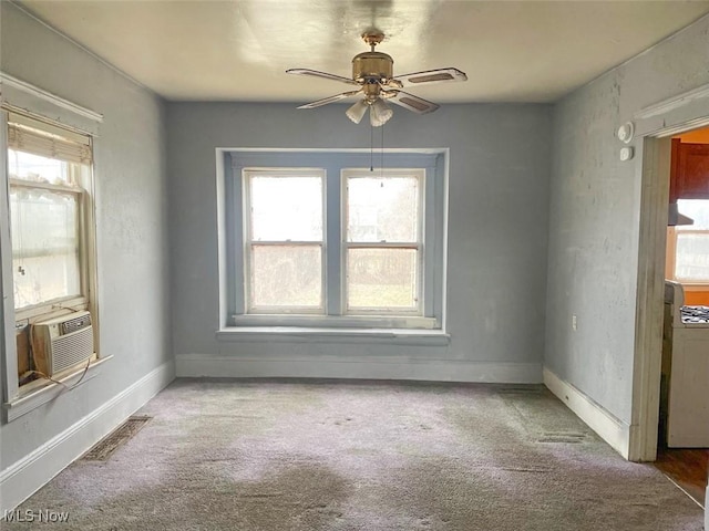 unfurnished room with carpet floors, a wealth of natural light, visible vents, and baseboards