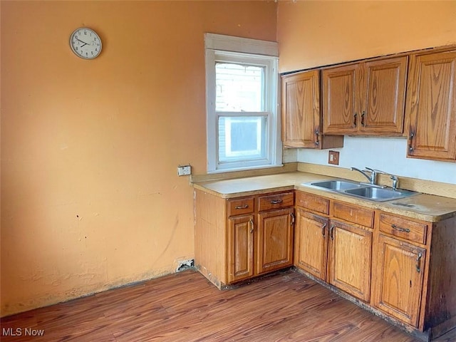 kitchen featuring brown cabinets, a sink, and wood finished floors