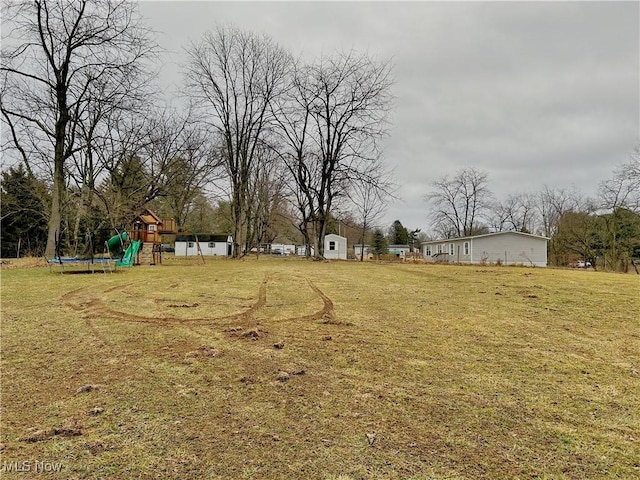 view of yard featuring a playground and a trampoline