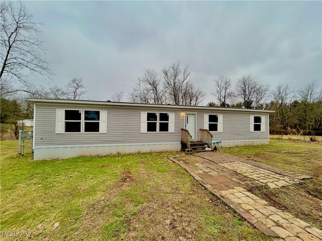 manufactured / mobile home with entry steps and a front lawn