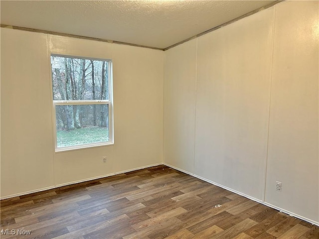 empty room featuring hardwood / wood-style flooring and a textured ceiling