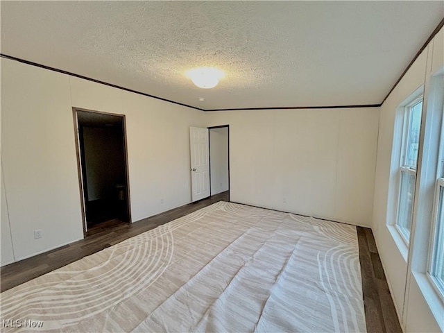 bedroom featuring hardwood / wood-style flooring, ornamental molding, and a textured ceiling